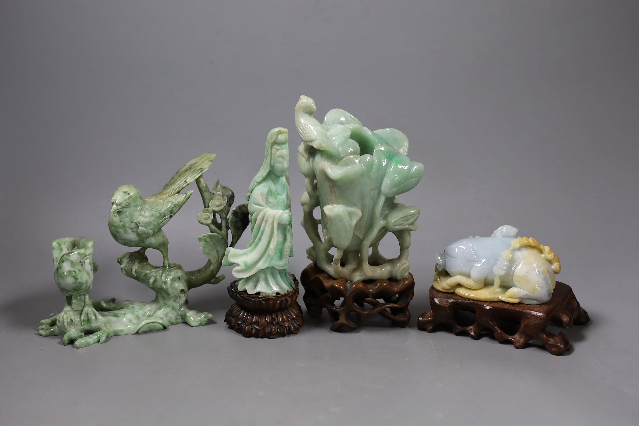 Four Chinese jadeite carvings, three on hardwood stands. Including a pig and piglets, two birds on a branch, a magnolia vase and a figure of Guanyin, Tallest 17.5cm including stand